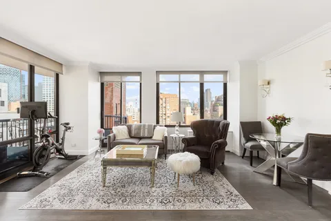 a living room with furniture a rug a lamp and a table
