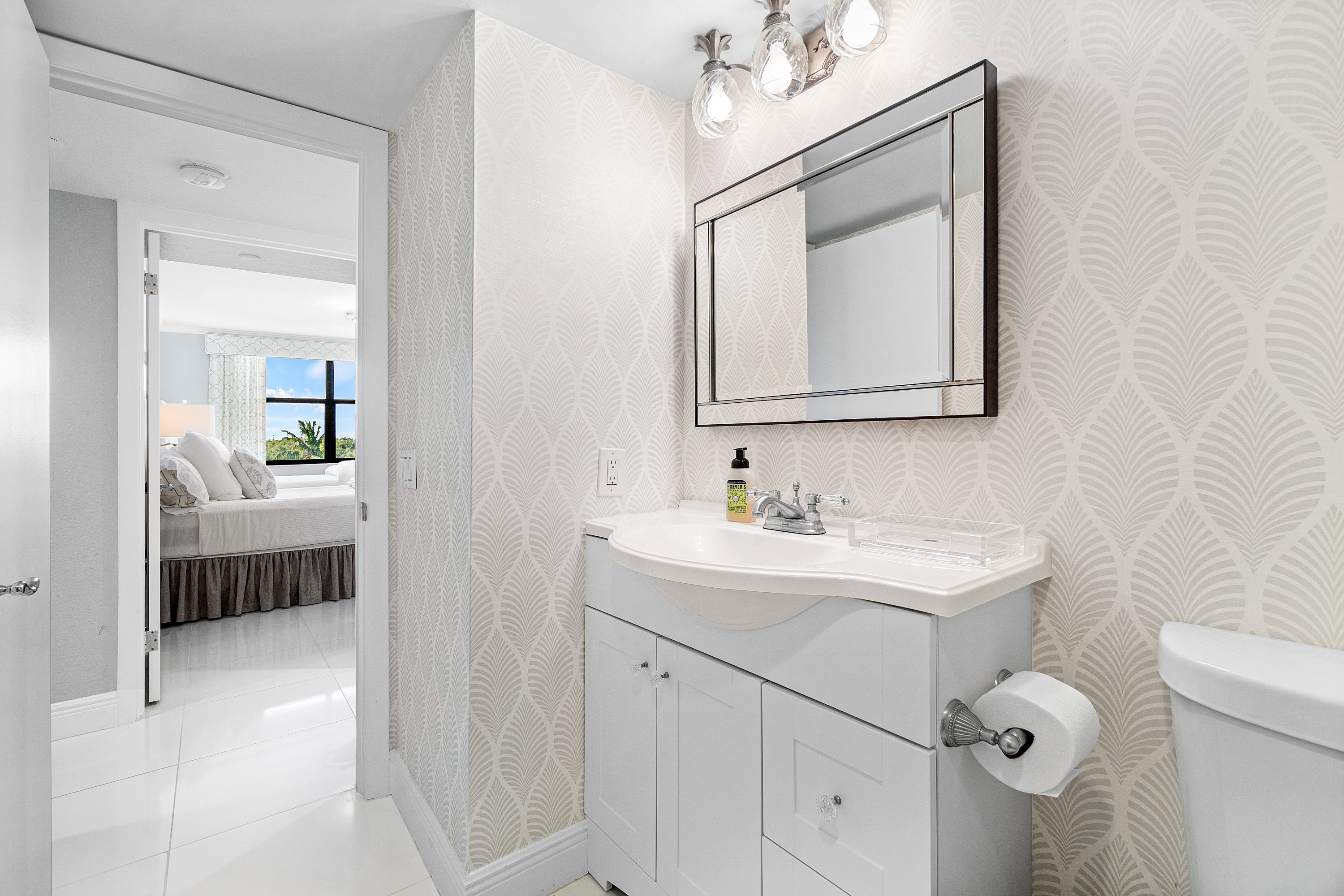 2003 North Ocean Boulevard, Unit 305 Boca Raton, FL 33431 - Photo 40 of 56 a en suite bathroom with a toilet sink and mirror