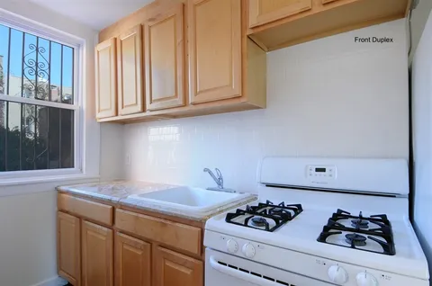 a kitchen with sink a stove and cabinets