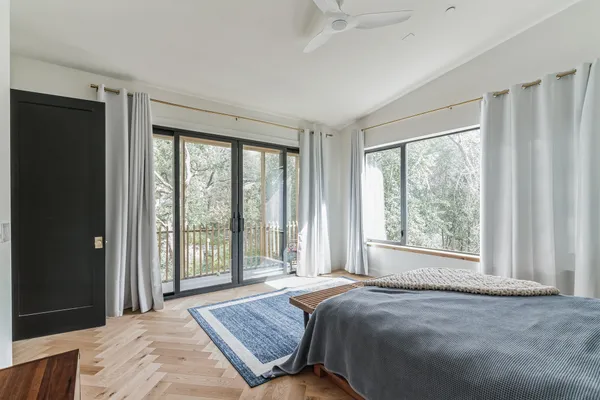 a bed sitting in a spacious bedroom next to a window