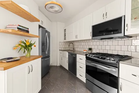 a kitchen with stainless steel appliances a stove a sink and a microwave