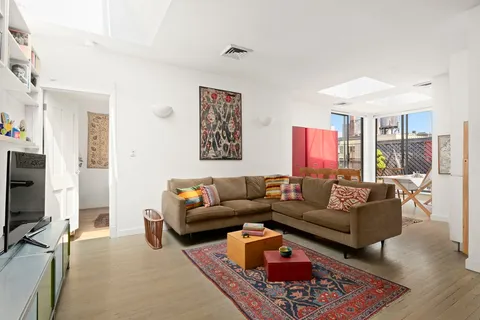 a living room with furniture a rug and a flat screen tv