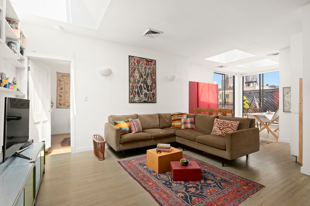 205 West 89th Street, Unit PH6/7 Manhattan, NY 10024 - Photo 12 of 20 a living room with furniture a rug and a flat screen tv