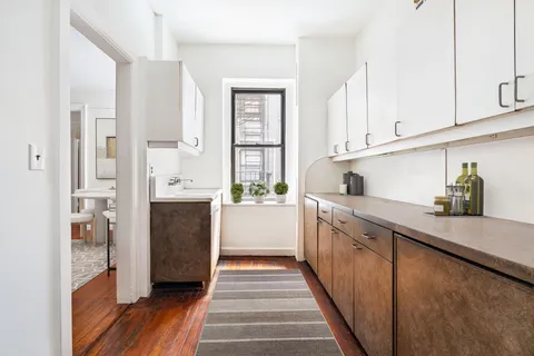 a kitchen with stainless steel appliances kitchen island granite countertop a refrigerator and a sink