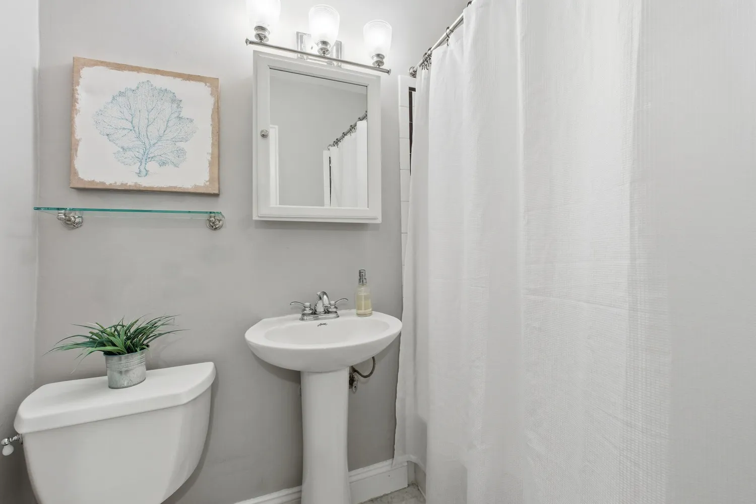 a bathroom with a sink toilet and a mirror