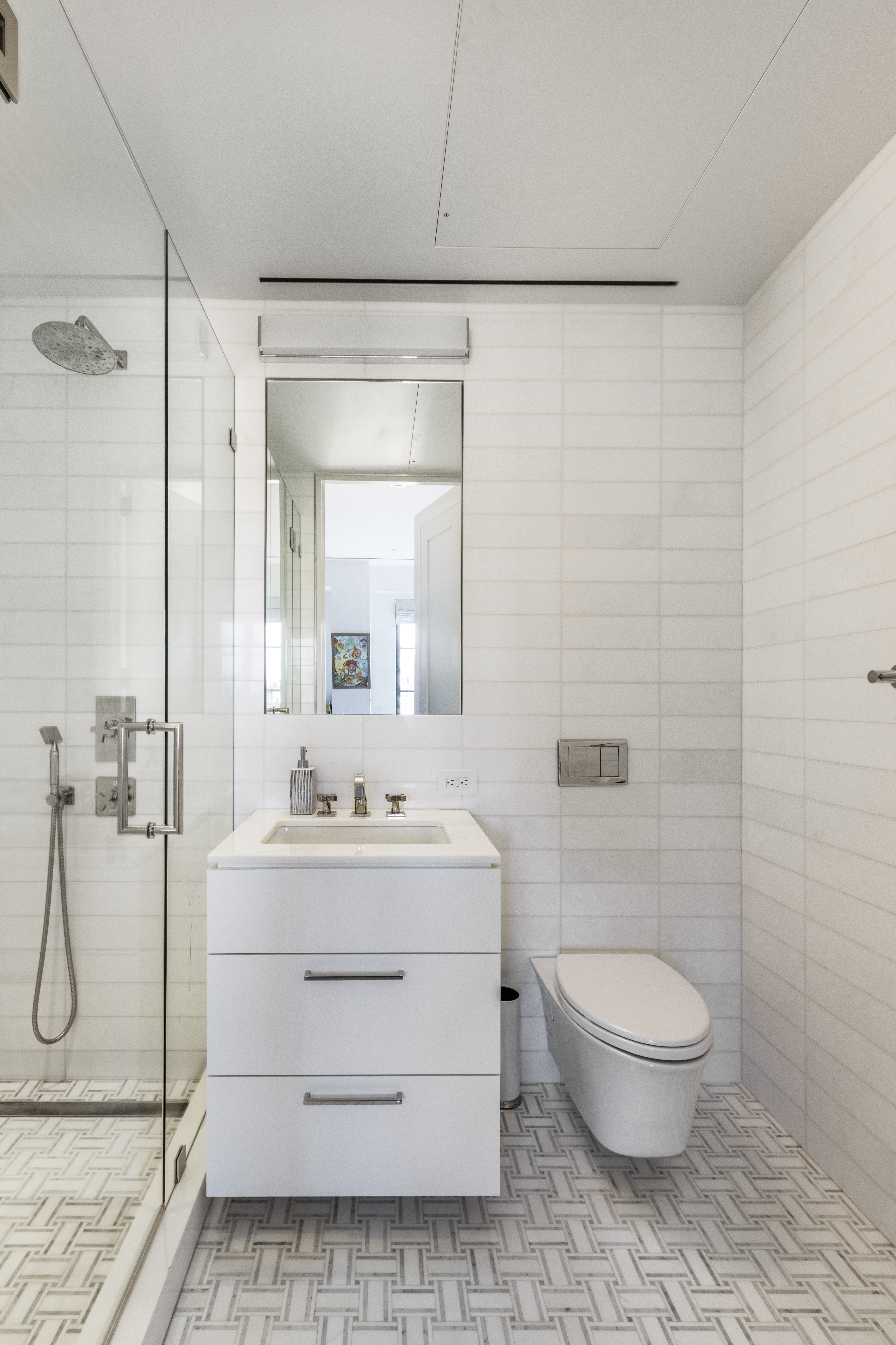 40 East 61st Street, Unit 18A Manhattan, NY 10065 - Photo 13 of 15 a bathroom with a sink a toilet and shower