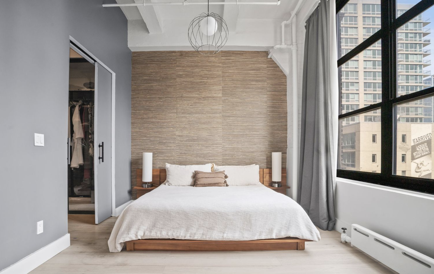 448 West 37th Street, Unit 8C Manhattan, NY 10018 - Photo 6 of 10 a bedroom with a bed and a large window