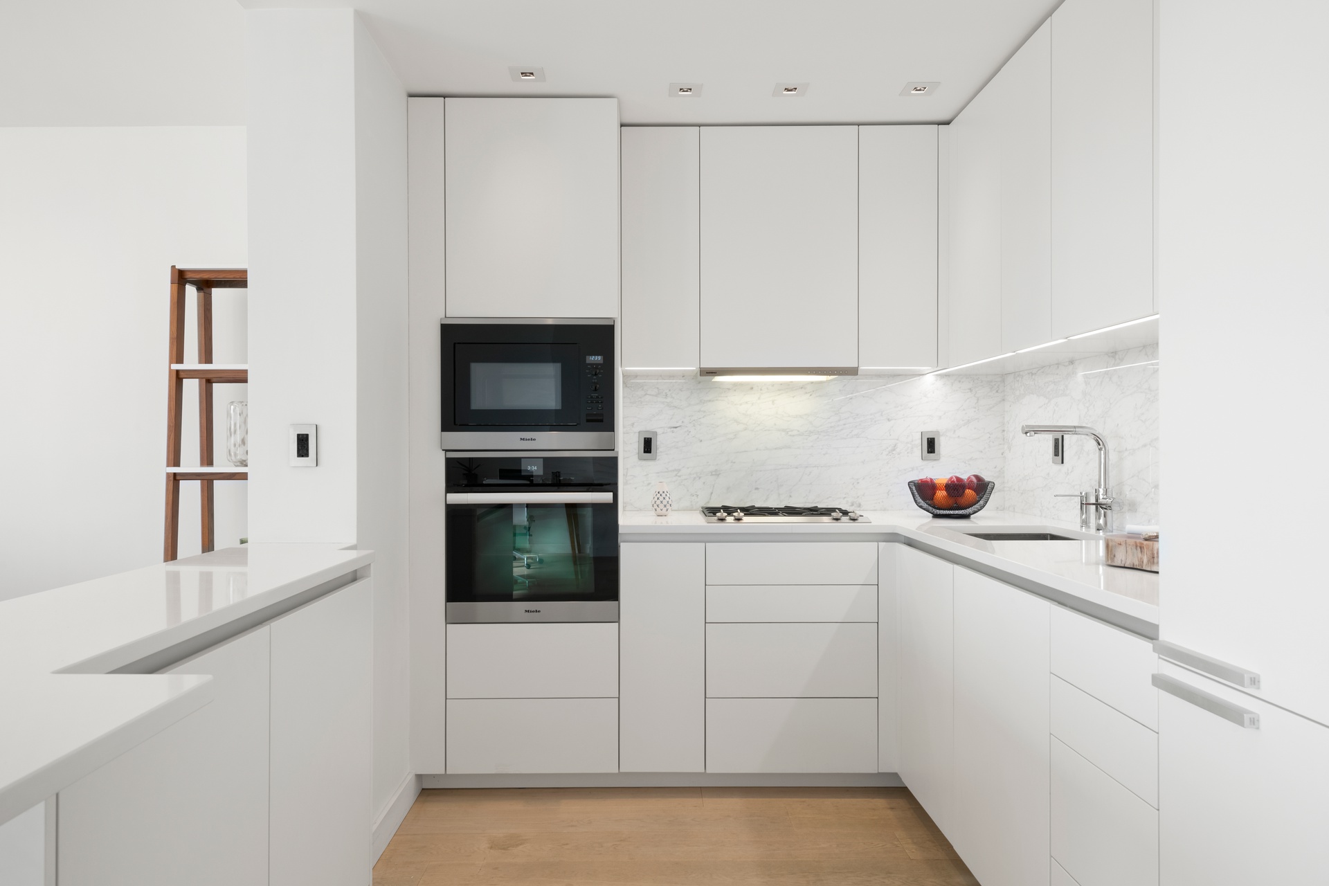 22 West 15th Street, Unit 19D Manhattan, NY 10011 - Photo 6 of 18 a kitchen with white cabinets and white appliances