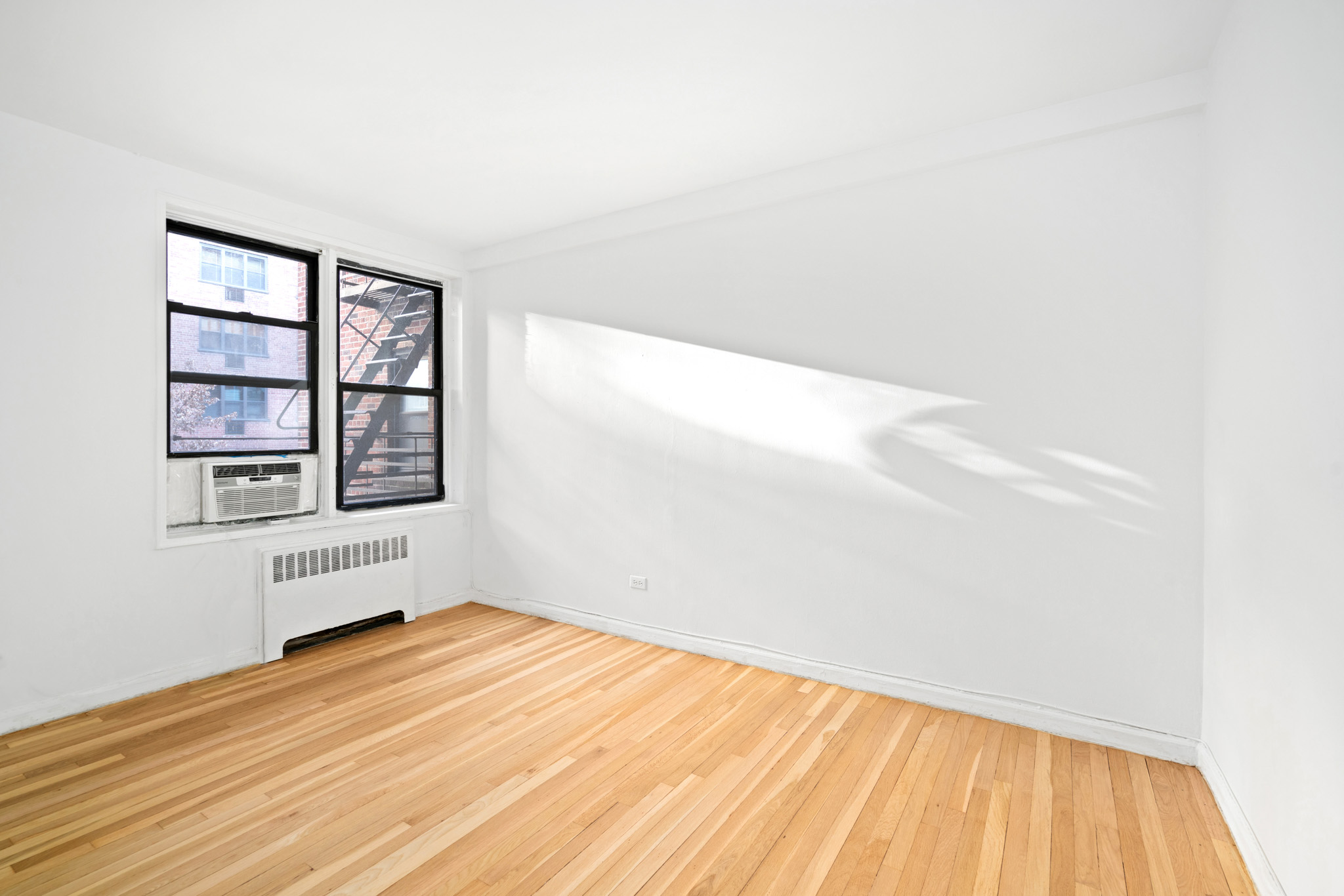 60 East 9th Street, Unit 235 Manhattan, NY 10003 - Photo 8 of 14 a view of empty room with wooden floor and fan