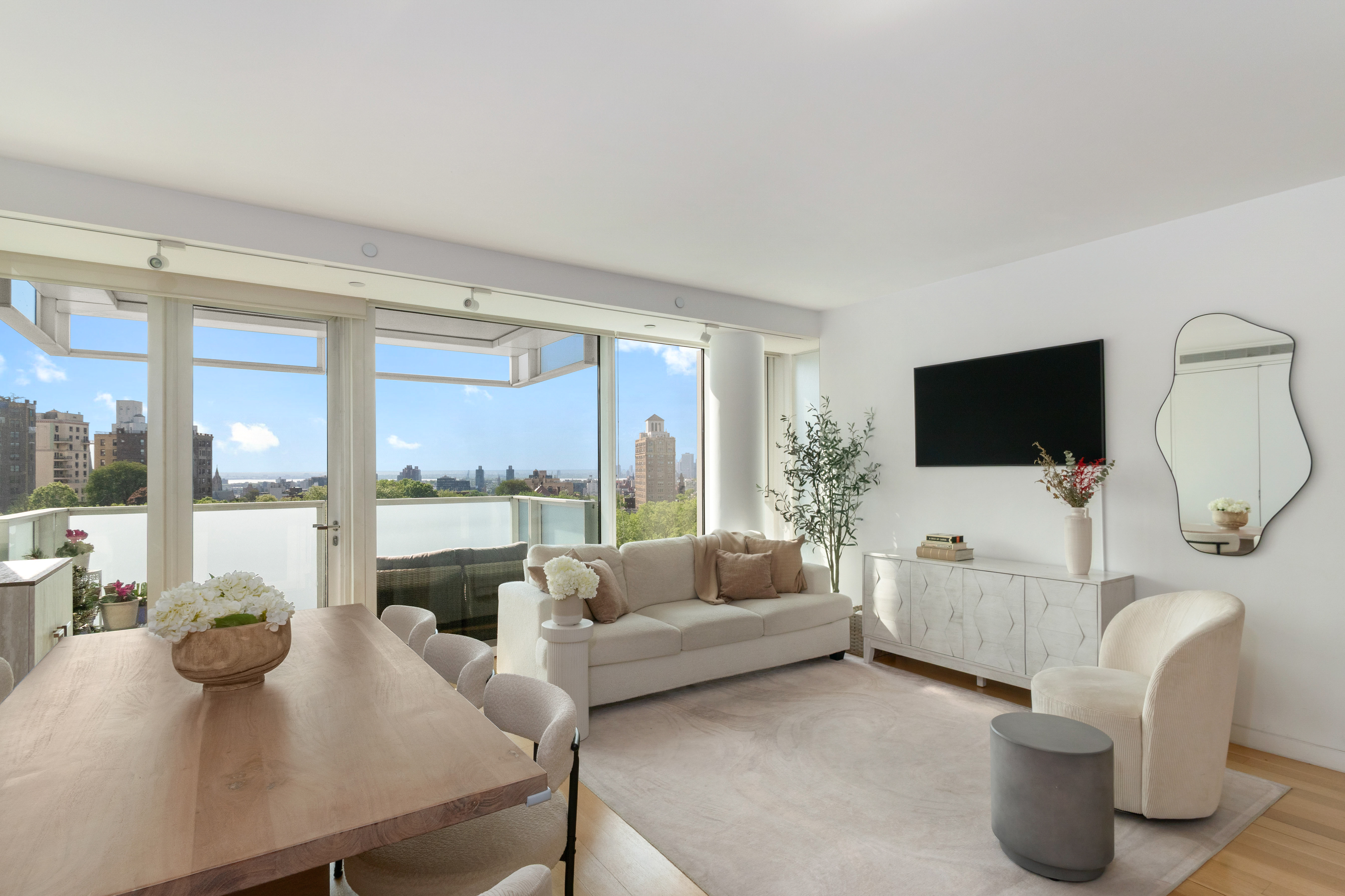 a living room with furniture a flat screen tv and a floor to ceiling window