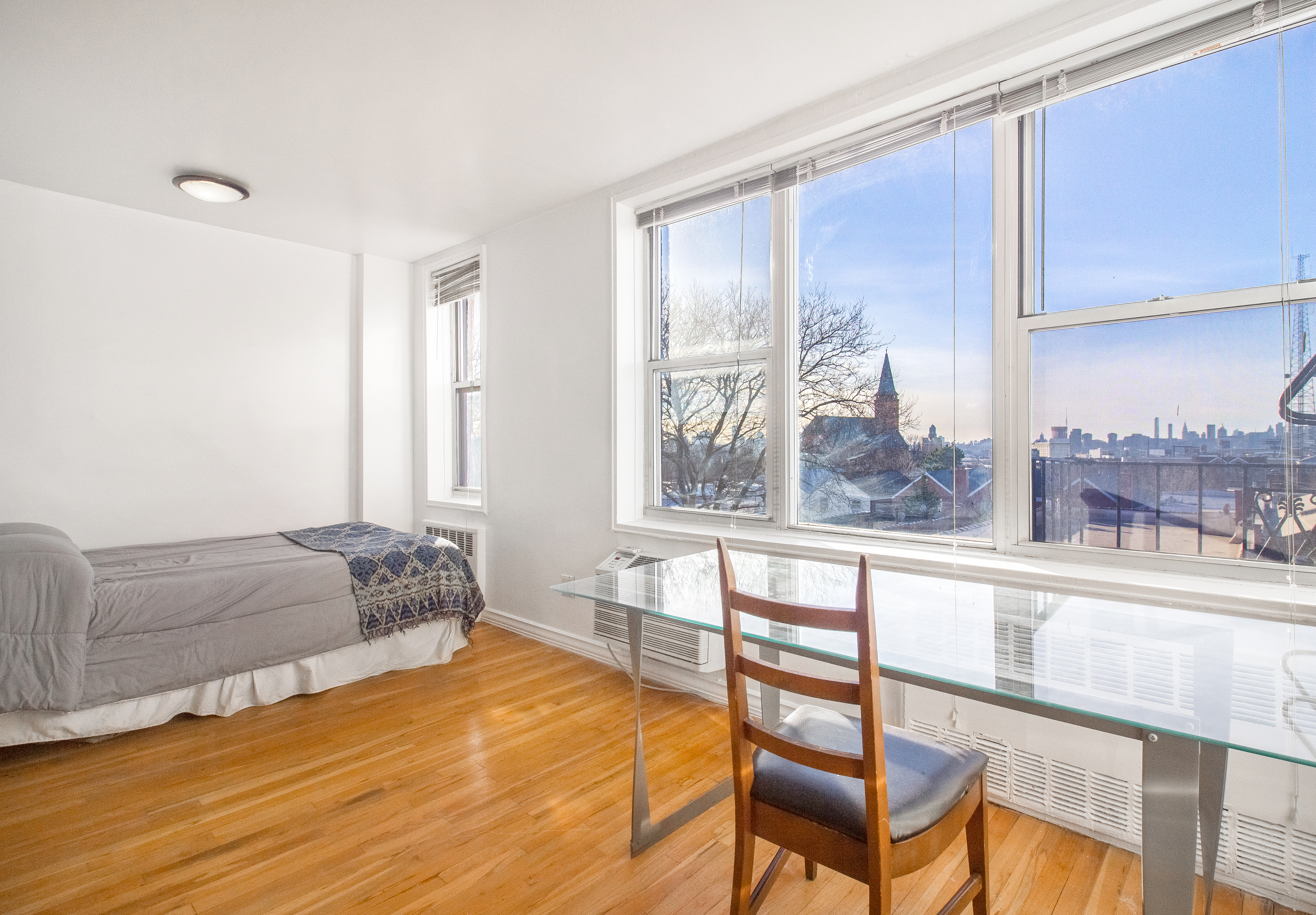 50-15 39th Street, Unit 4C Queens, NY 11104 - Photo 3 of 10 a bedroom with a bed and a large window