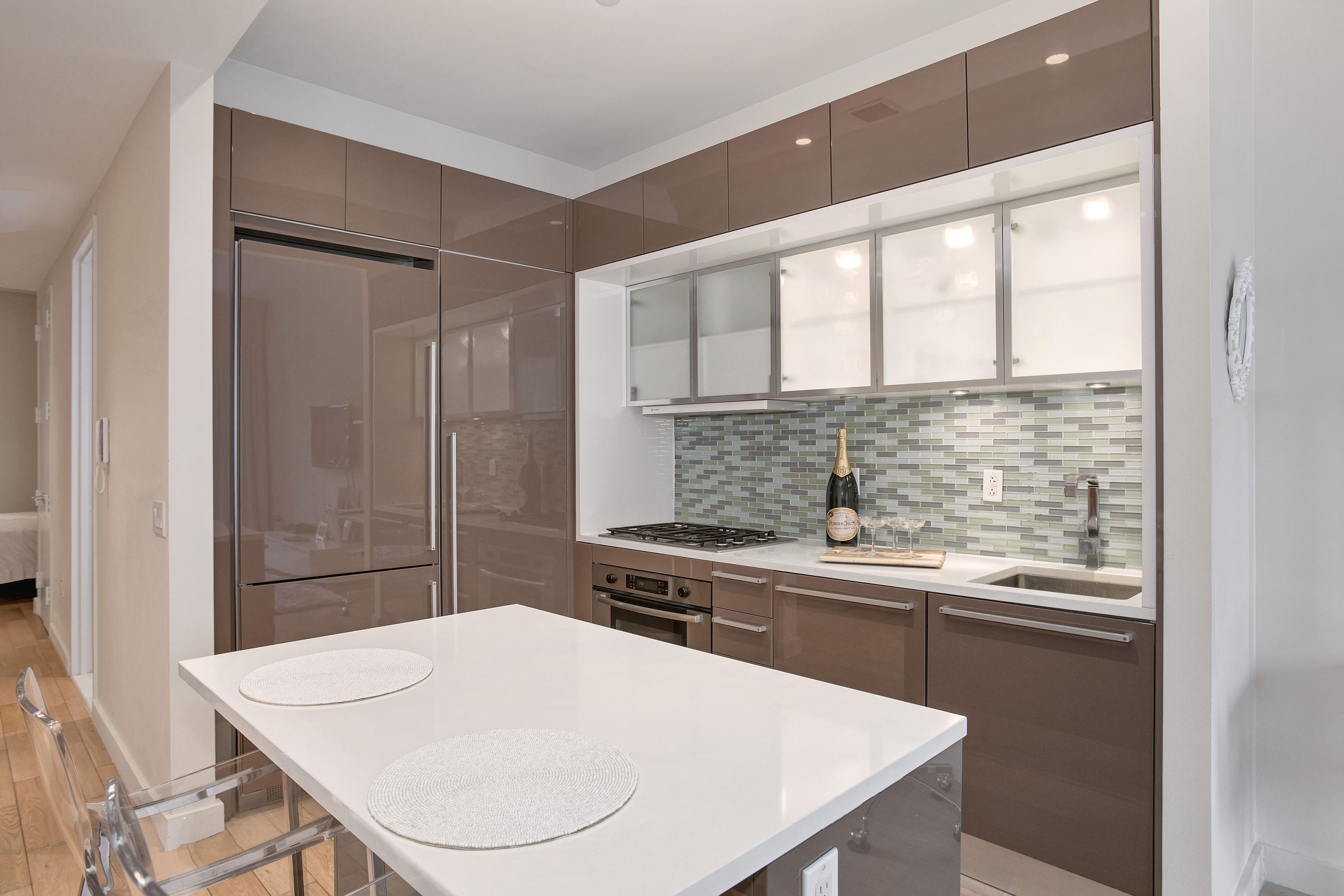 75 Wall Street, Unit 26D Manhattan, NY 10005 - Photo 2 of 11 a kitchen with a table a sink and cabinets