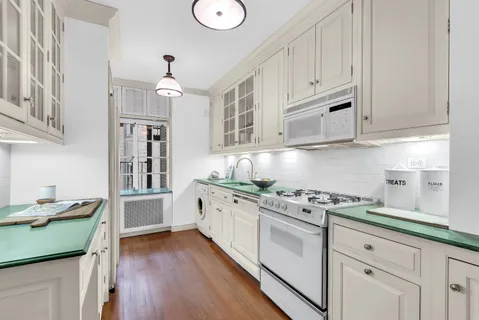 a kitchen with stainless steel appliances granite countertop a sink a stove and cabinets