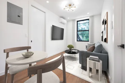a living room with furniture a flat screen tv and a window