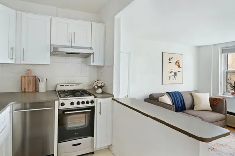 a kitchen with stainless steel appliances granite countertop a stove a refrigerator and a white cabinets