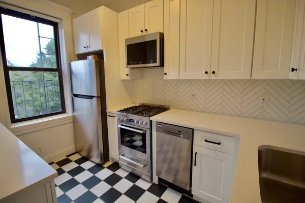 a kitchen with a refrigerator a stove a microwave and cabinets
