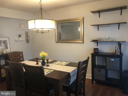 a dining room with furniture a chandelier and wooden floor