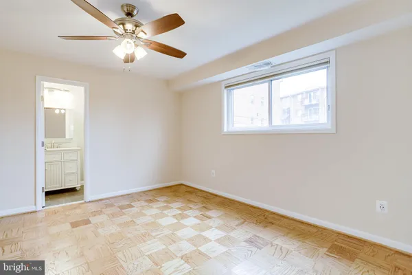 an empty room with a window and a fan
