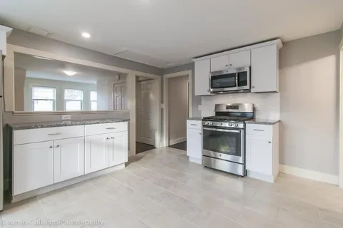 a kitchen with stainless steel appliances white cabinets and a sink