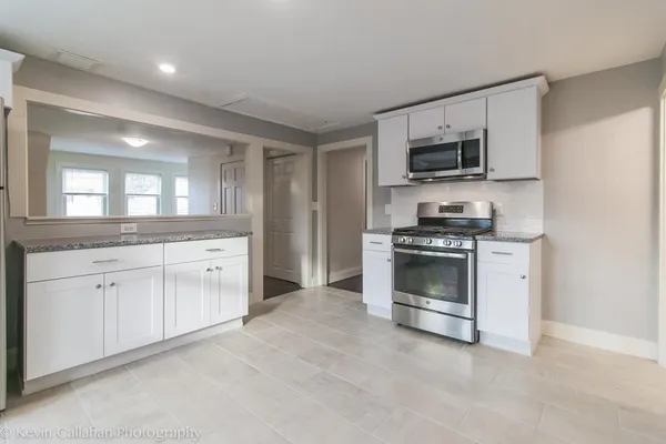 a kitchen with stainless steel appliances white cabinets and a sink