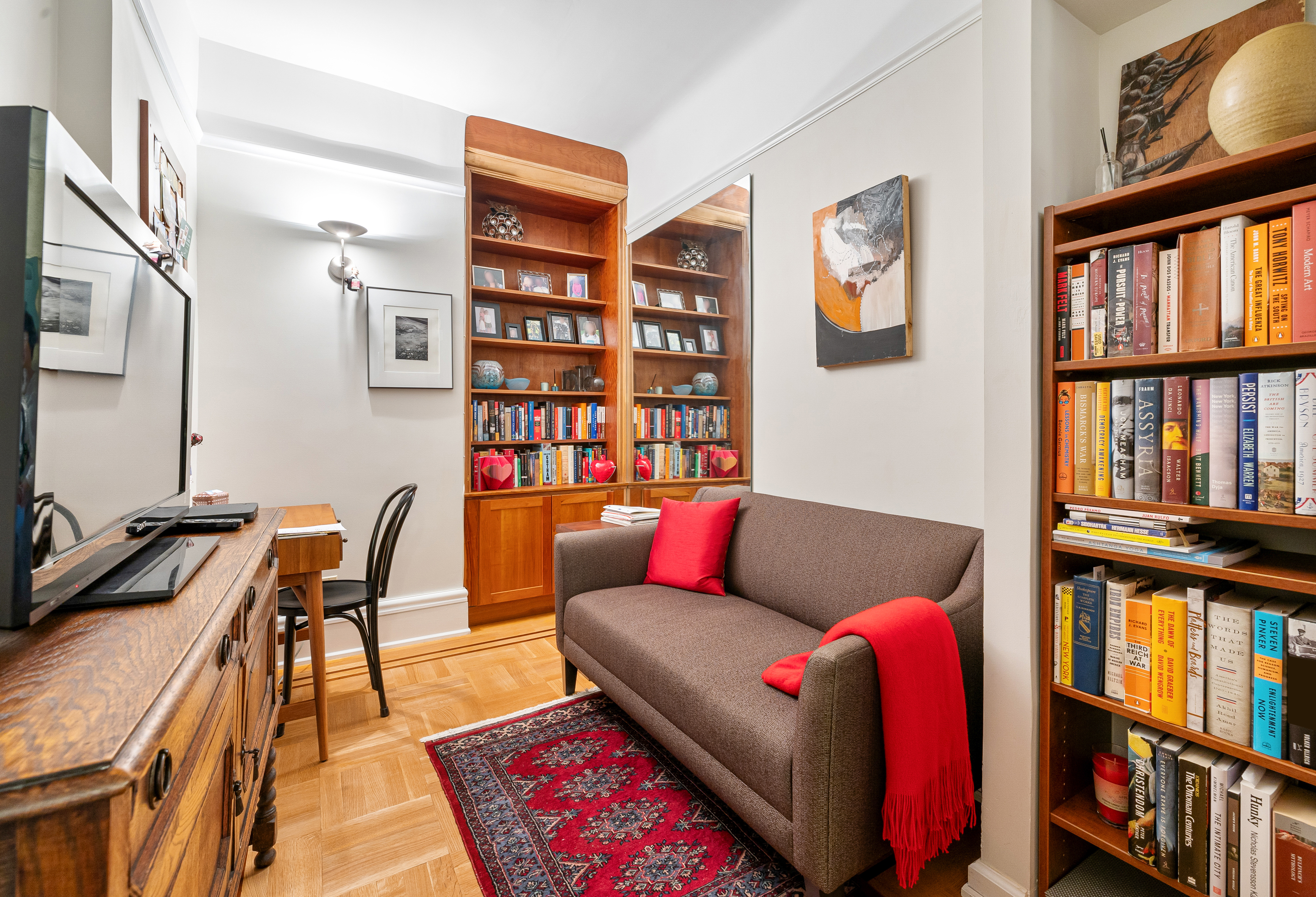 200 West 54th Street, Unit 9G Manhattan, NY 10019 - Photo 11 of 17 a living room with furniture a bookshelf and a window