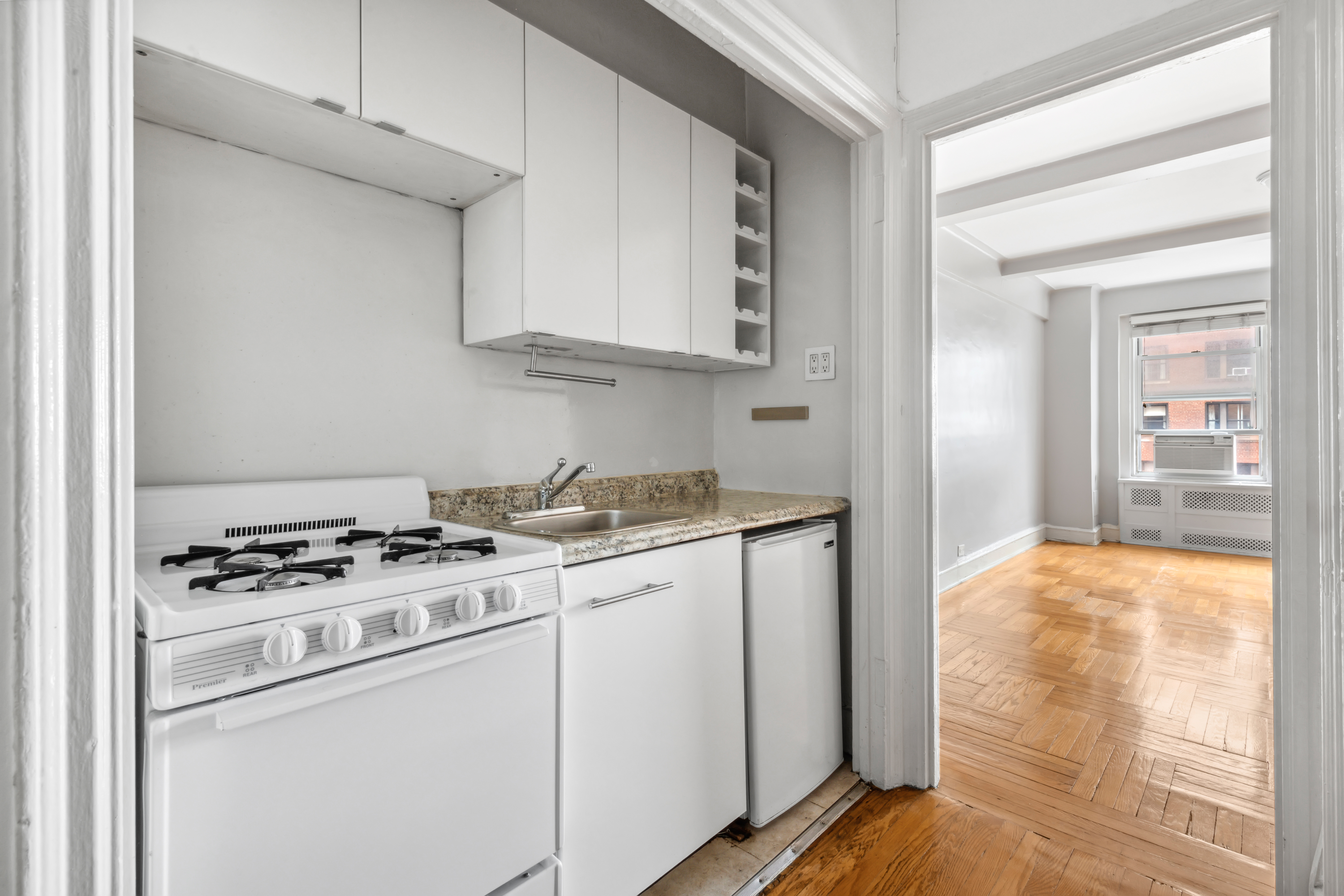 433 West 34th Street, Unit 8D Manhattan, NY 10001 - Photo 6 of 15 a kitchen with white cabinets and white appliances