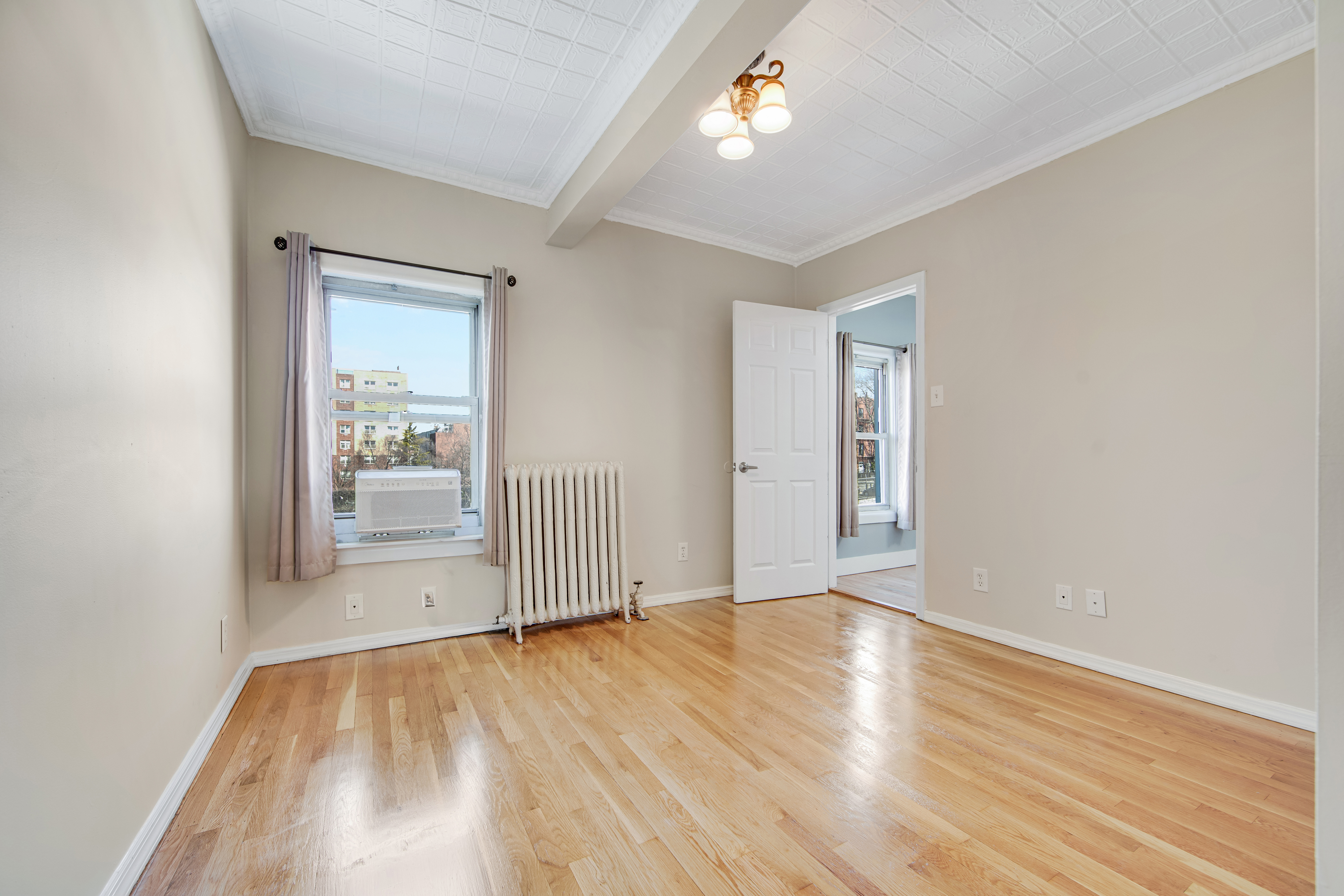 296 17th Street Brooklyn, NY 11215 - Photo 5 of 8 an empty room with wooden floor and windows