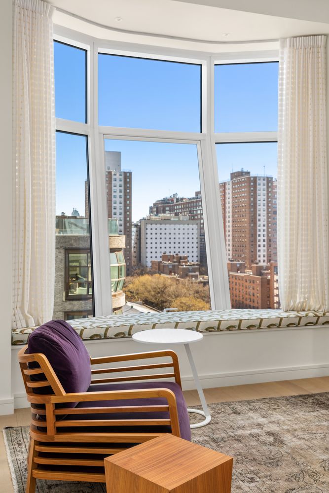 a living room with a large window and a wooden floor