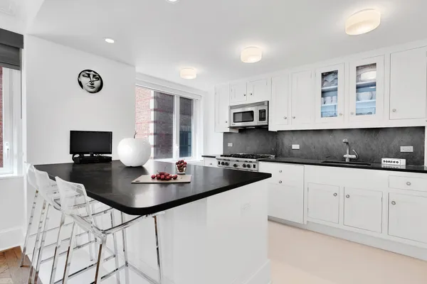 a kitchen with stainless steel appliances kitchen island granite countertop a sink a stove a microwave a counter space and cabinets