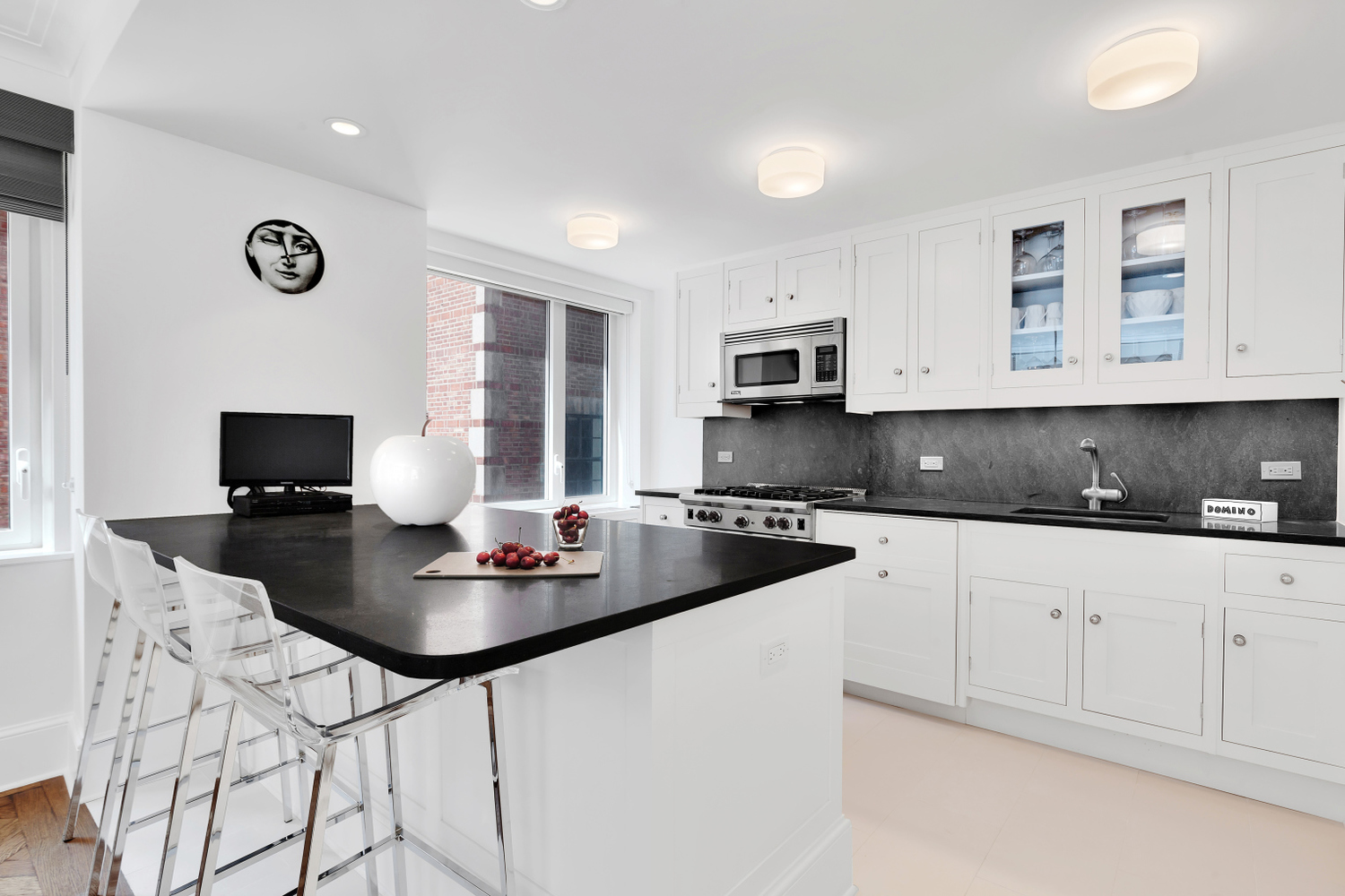 530 Park Avenue, Unit 4A Manhattan, NY 10065 - Photo 5 of 16 a kitchen with stainless steel appliances kitchen island granite countertop a sink a stove a microwave a counter space and cabinets