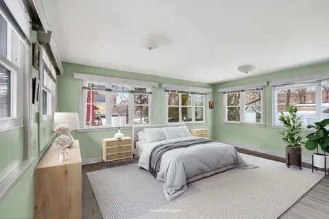 a bedroom with a large bed and a potted plant