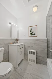 a bathroom with a toilet a sink and mirror