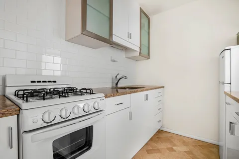 a white stove top oven sitting inside of a kitchen