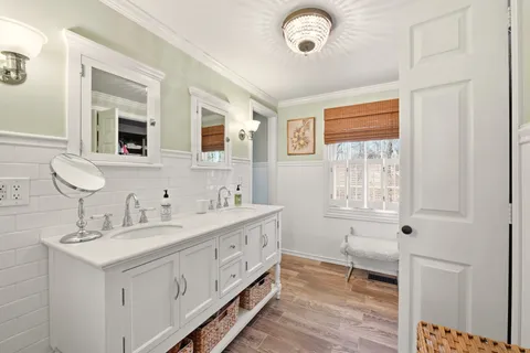 a bathroom with double vanity sink a mirror and a bathtub