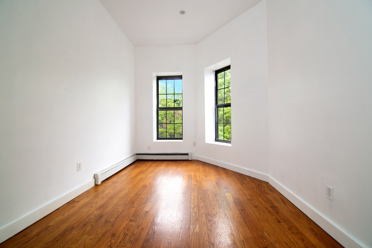900 Lafayette Avenue Brooklyn, NY 11221 - Photo 10 of 13 an empty room with wooden floor and windows