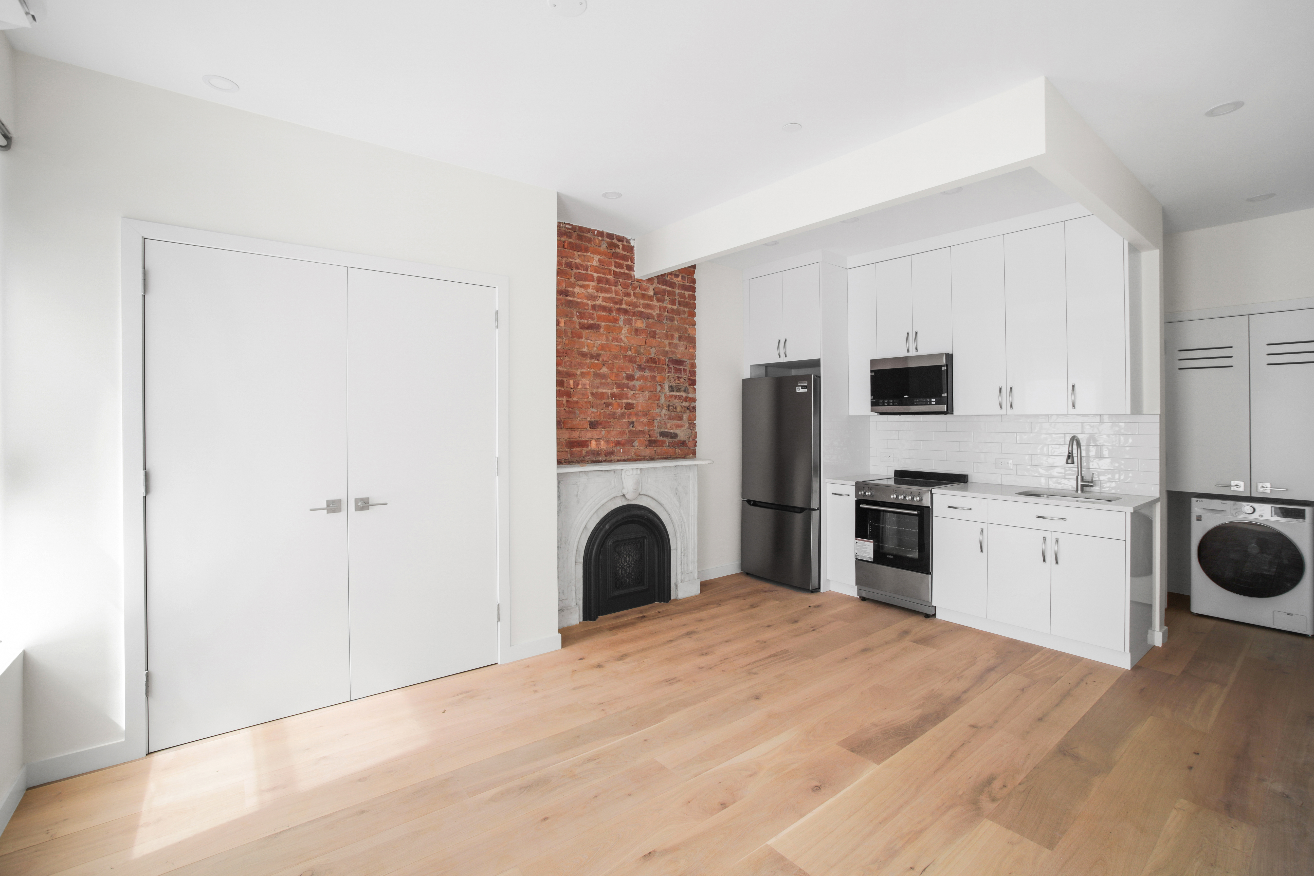 94 6th Avenue, Unit 3F Brooklyn, NY 11217 - Photo 2 of 11 a kitchen with a refrigerator sink and white cabinets