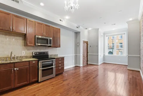 a kitchen with stainless steel appliances wooden floors and wooden cabinets