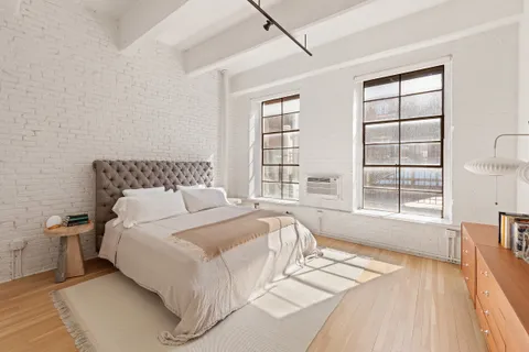 a spacious bedroom with a bed and a large window