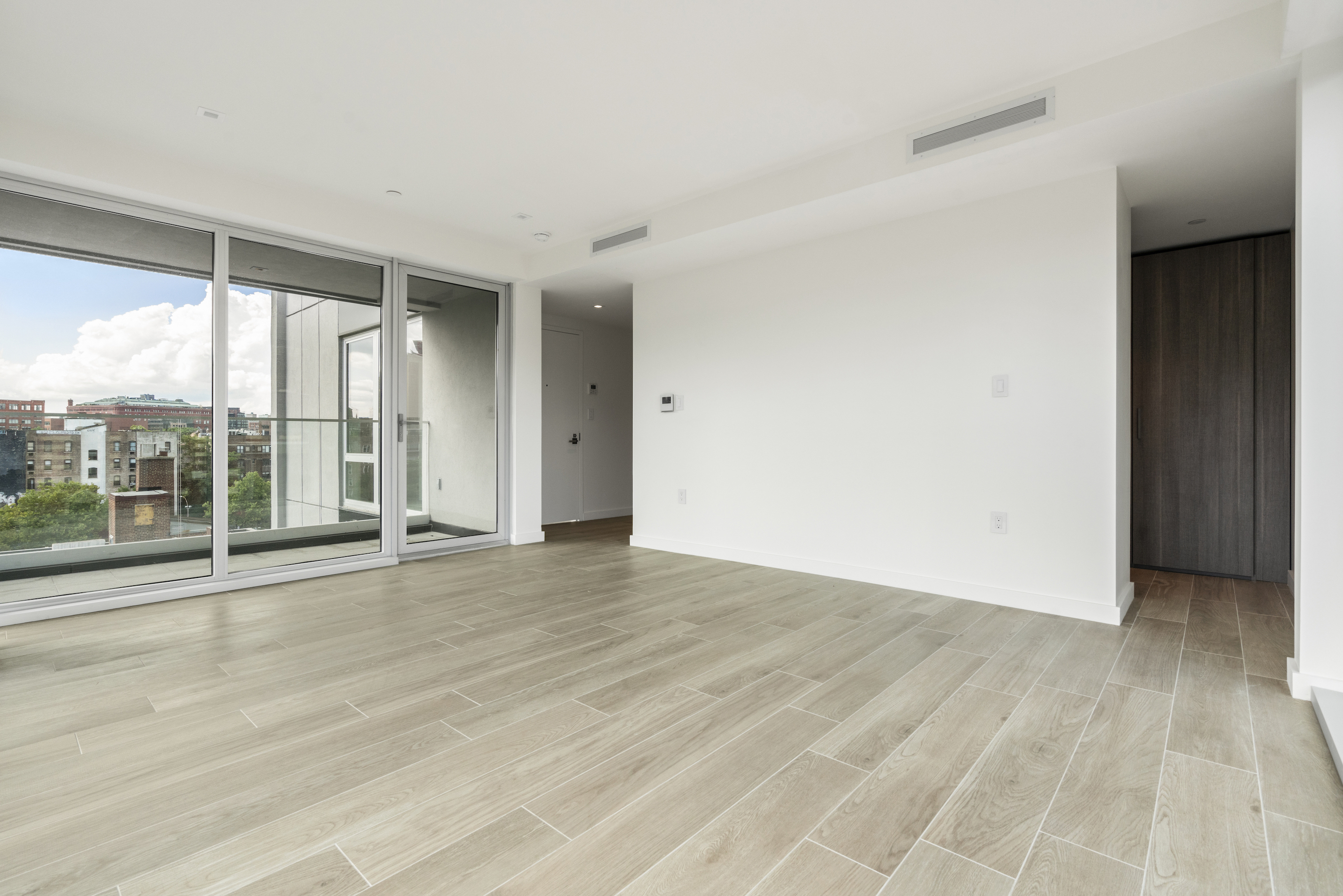 136 West Houston Street, Unit 6 Manhattan, NY 10012 - Photo 3 of 14 an empty room with wooden floor and windows