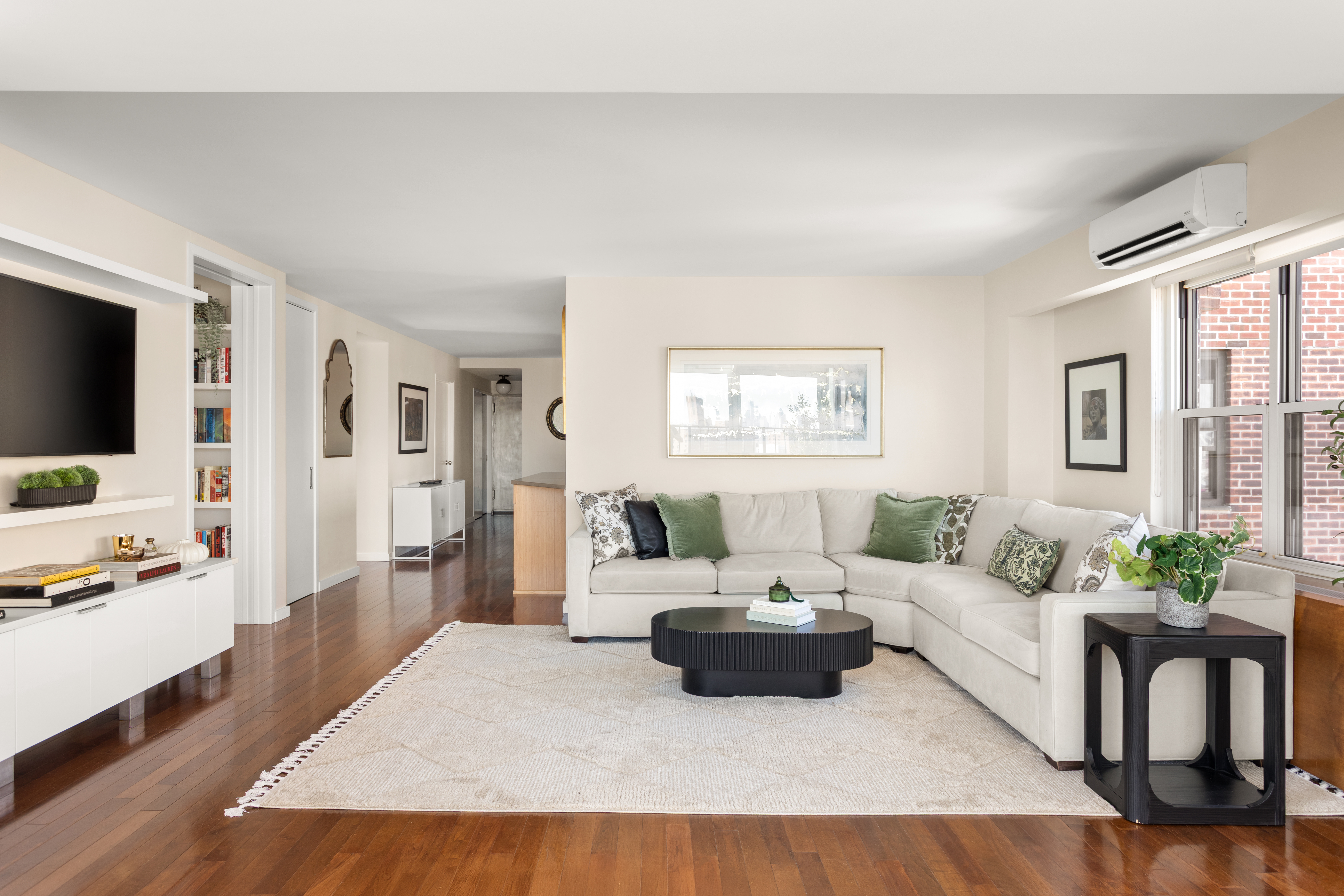 417 Grand Street, Unit D1801 Manhattan, NY 10002 - Photo 4 of 23 a living room with furniture and a flat screen tv