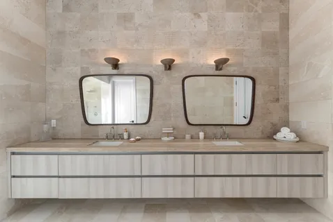 a bathroom with double vanity sinks and a mirror