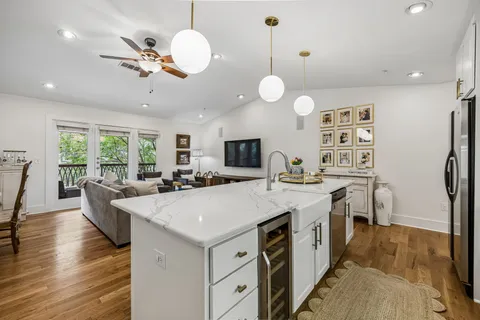 a view of a kitchen counter top space a sink stove and living room view