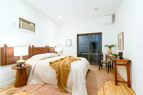 a bedroom with a bed and wooden floor