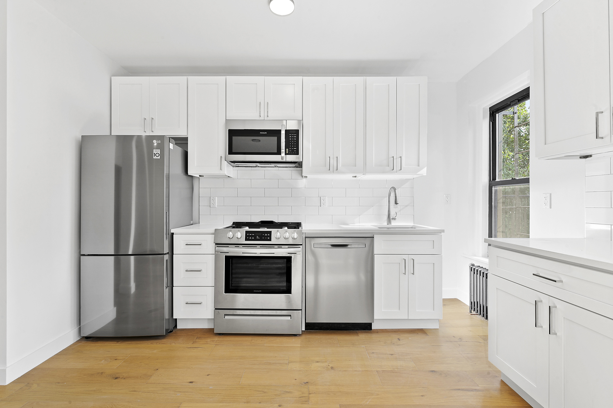 82 Clinton Avenue, Unit 1 Brooklyn, NY 11205 - Photo 3 of 11 a kitchen with stainless steel appliances white cabinets and a refrigerator