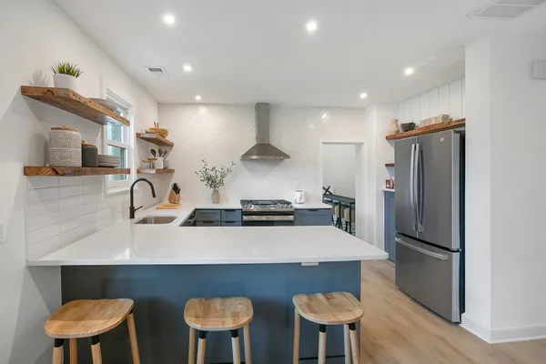a kitchen with stainless steel appliances a sink and a refrigerator