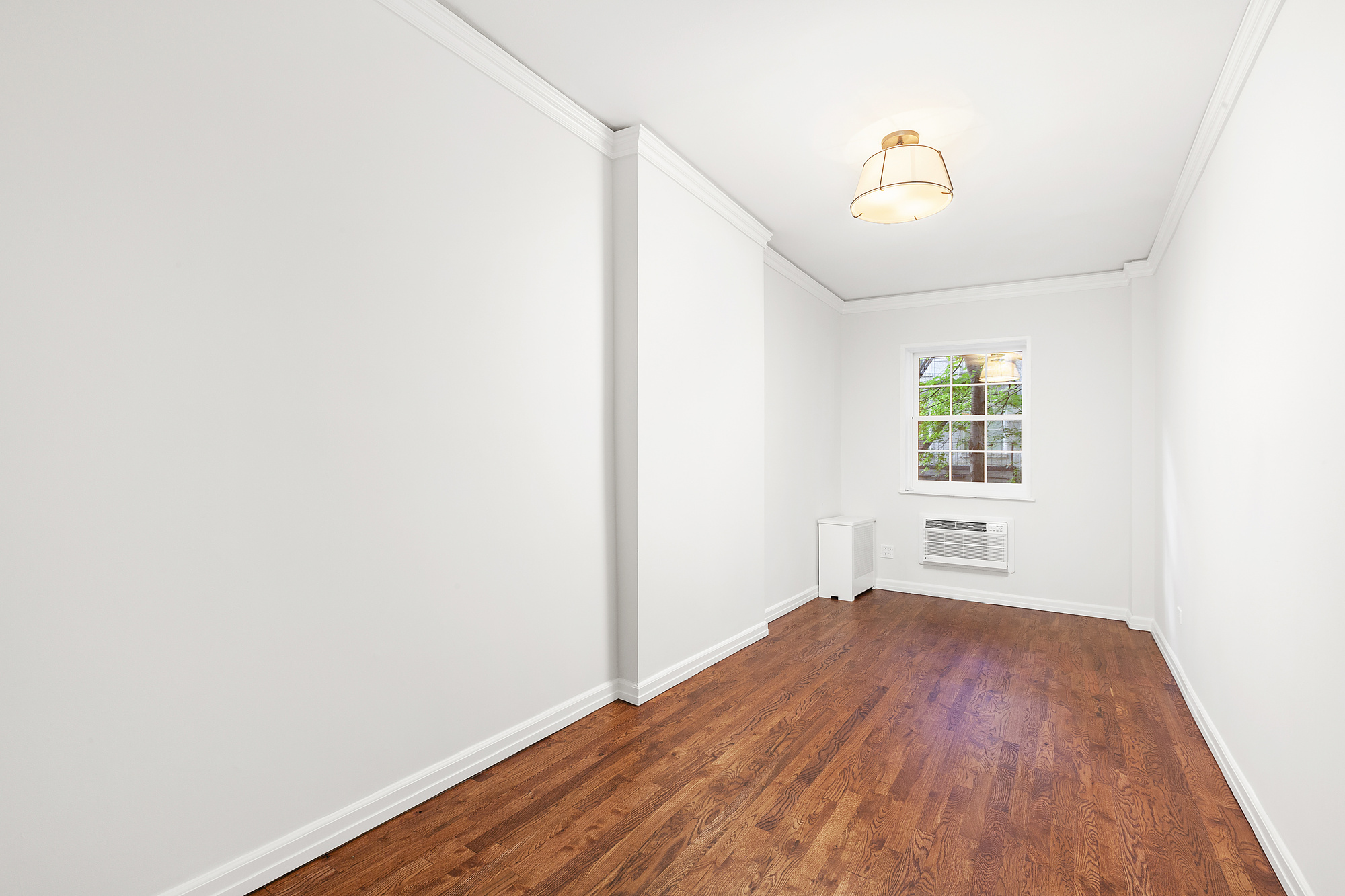 522 East 82nd Street, Unit 1 Manhattan, NY 10028 - Photo 11 of 16 a view of a room with wooden floor and white walls