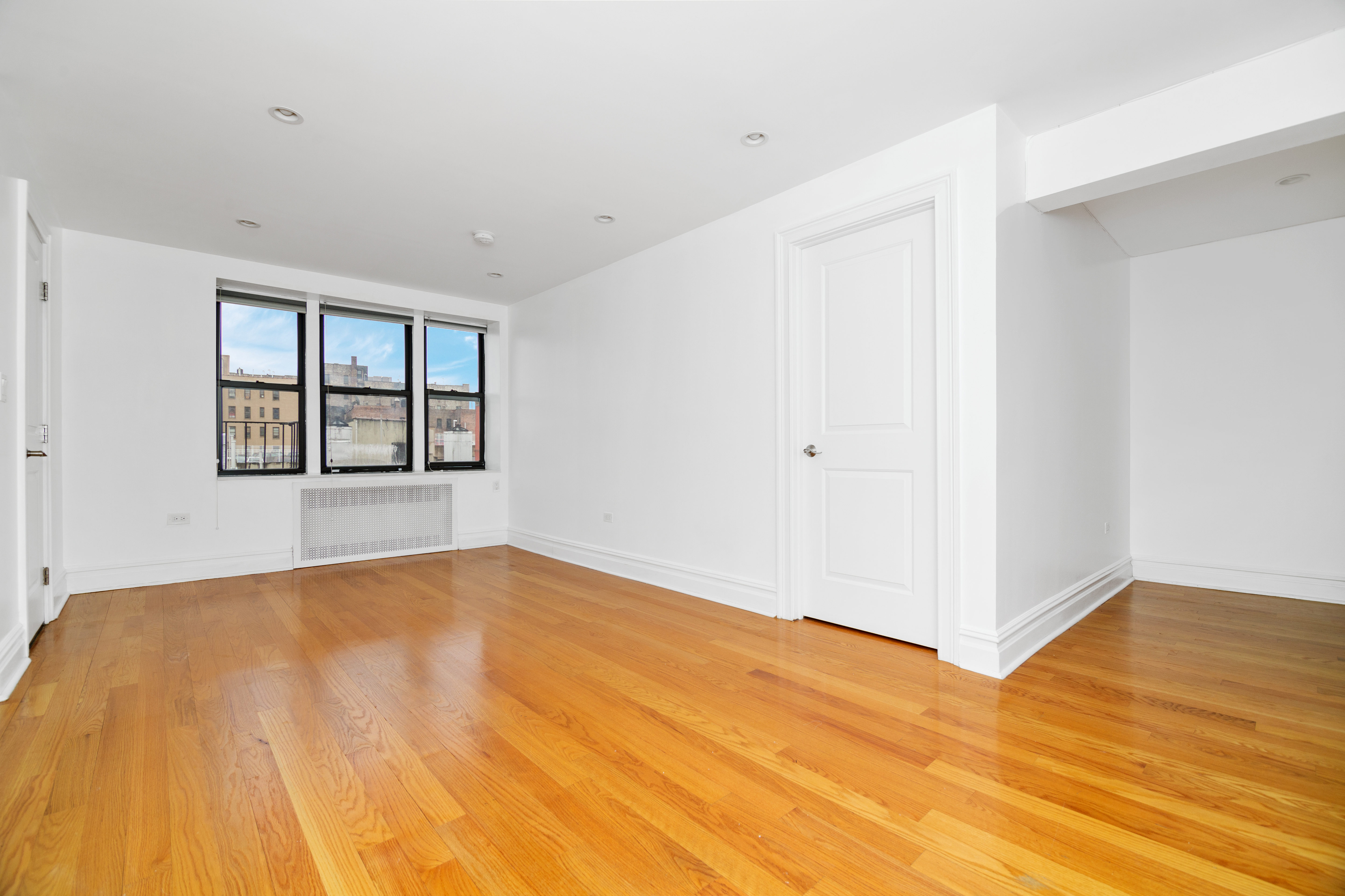 69 Bennett Avenue, Unit 608 Manhattan, NY 10033 - Photo 2 of 6 a view of empty room with wooden floor and fan