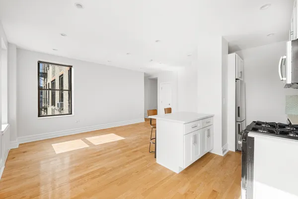 a kitchen with cabinets and wooden floor