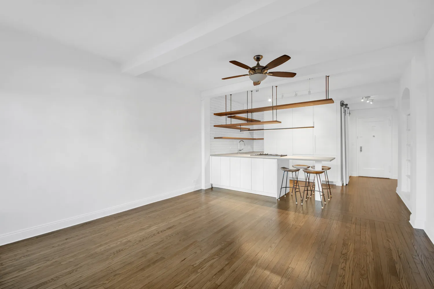 a view of a kitchen with wooden floor and a ceiling fan