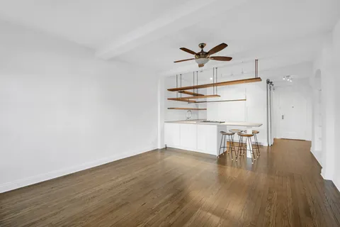 a view of a kitchen with wooden floor and a ceiling fan